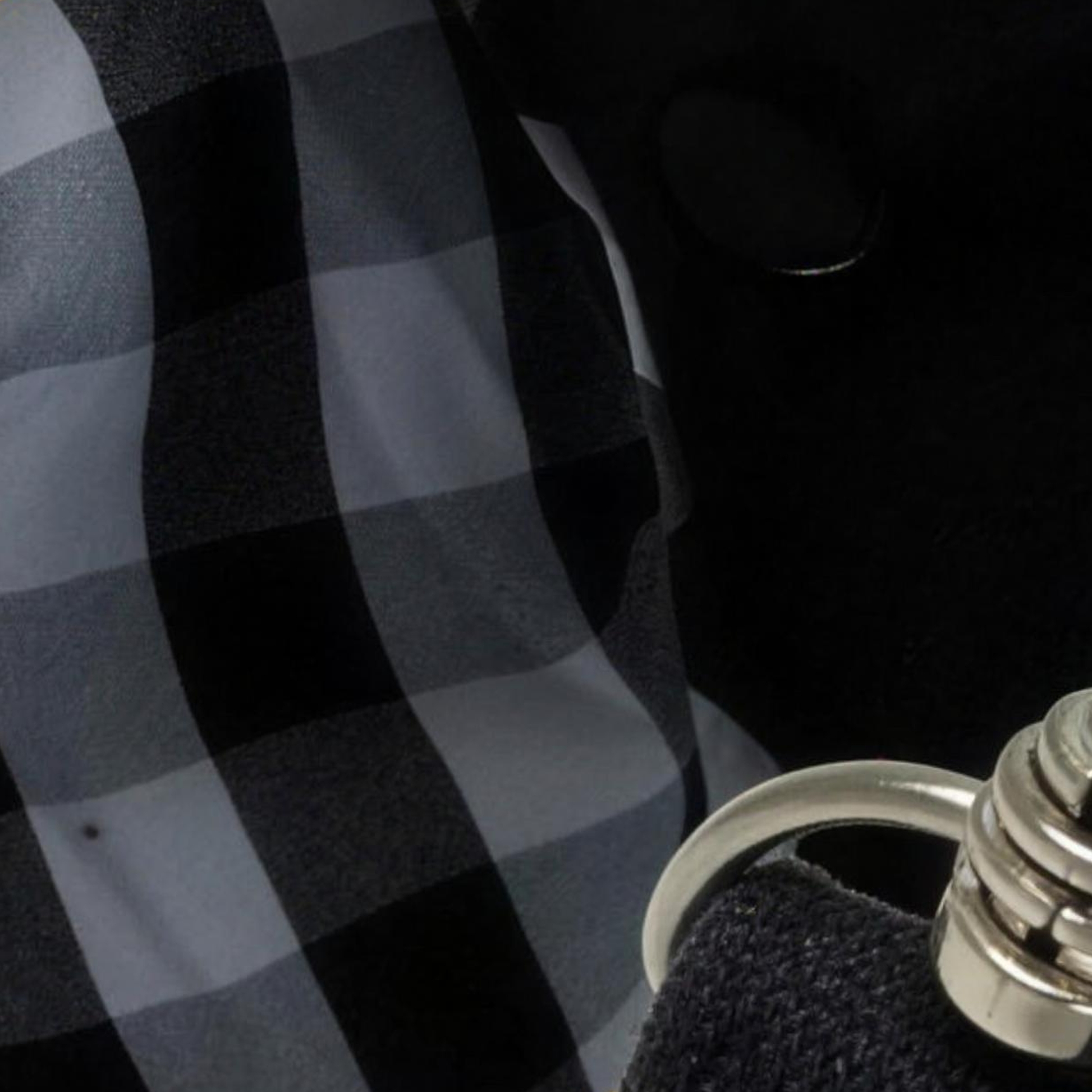 Nahaufnahme kariertes Baumwollfutter, Druckknopf und Karabiner der Sicherungsleine